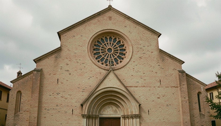 Immagine illustrativa: facciata di chiesa in laterizio con rosone circolare traforato e pronao ad arco acuto, cielo coperto e ombre morbide