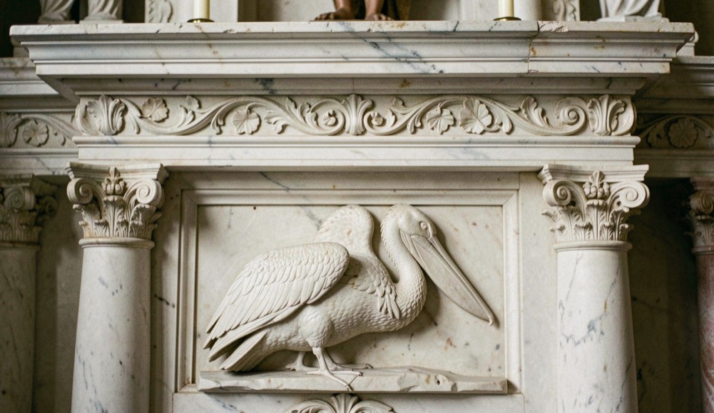 Immagine illustrativa: bassorilievo marmoreo su paliotto d’altare raffigurante un pellicano che si becca il petto, cornice a fregio vegetale